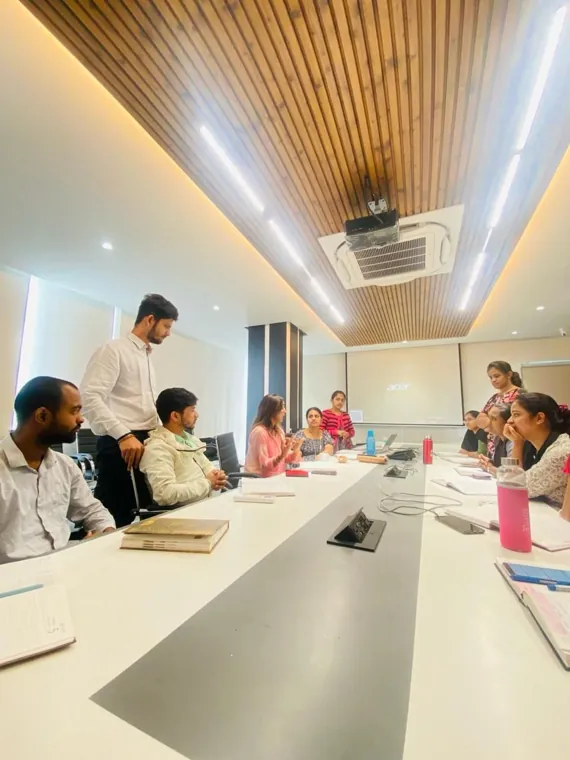 Trainer leading a session for a team around a boardroom table