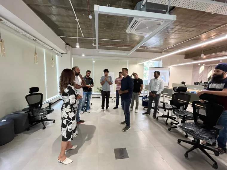 Trainer addressing a team in an open plan office