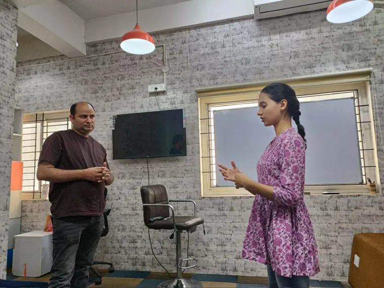 Two participants practising a conversation in front of the trainer